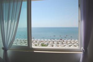 a window with a view of a beach and the ocean at estea in Castellaneta Marina