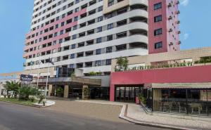 a tall pink building with a street in front of it at Tulip Inn Fortaleza in Fortaleza