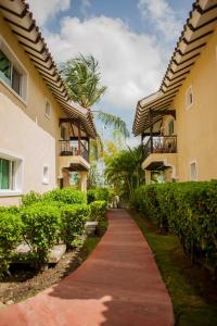 einen Weg zwischen zwei Gebäuden mit einer Palme in der Unterkunft Cocotal Bavaro Apartments in Punta Cana