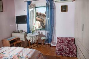 a bedroom with a bed and a table and a mirror at Buga And Tuga Rooms in Split
