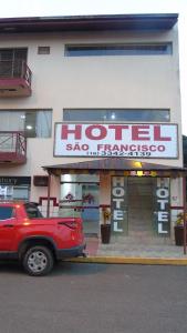 a red car parked in front of a store at Hotel São Francsico de Ibitinga in Ibitinga