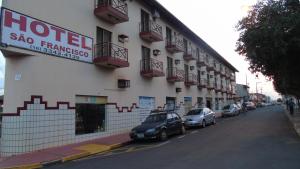 a hotel with cars parked on the side of a street at Hotel São Francsico de Ibitinga in Ibitinga