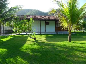 a house with two palm trees in a yard at Chácara Vale de Imbaú in Imbau