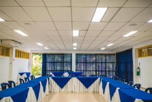 una sala de conferencias con mesa azul y sillas en Hotel Campestre Tacurrumbi, en Montenegro