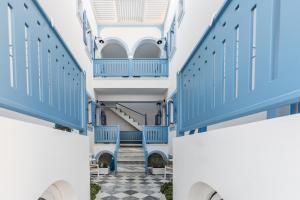 een hal met blauwe deuren en een geruite vloer bij Fanouris Condo - Adults Only in Kamari