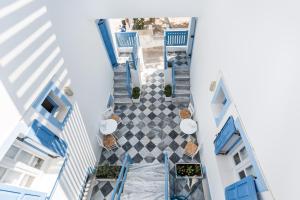 una vista aérea de un suelo de baldosa en un edificio con sillas y mesas azules en Fanouris Condo - Adults Only, en Kamari