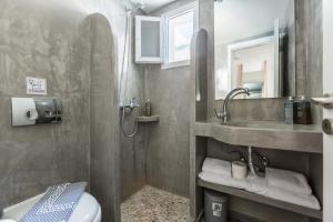 een badkamer met douche, wastafel en toilet bij Fanouris Condo - Adults Only in Kamari +16 foto's