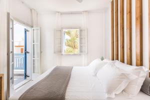 カマリにあるFanouris Condo - Adults Onlyの白いベッドルーム(ベッド1台、窓付)