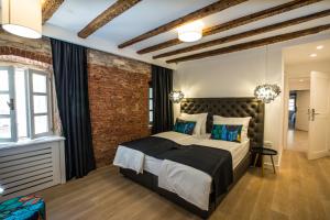 a bedroom with a large bed and a brick wall at Spalato Luxury Rooms in Split