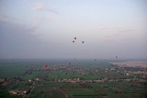 a group of hot air balloons flying in the sky at Cleopatra Hotel Luxor in Luxor