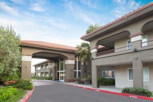 a view of a hotel building with a patio at Baymont by Wyndham Modesto Salida in Modesto