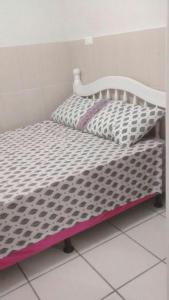 a small bed with a white bed frame and a pillow at Hostel Fariafaz in Gaspar