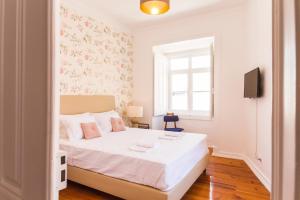 een slaapkamer met een wit bed en een raam bij City Lofts Lisbon - Guesthouse in Lissabon