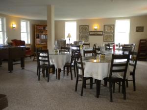 un comedor con mesas y sillas en una habitación en The Sterling Inn, en Caratunk