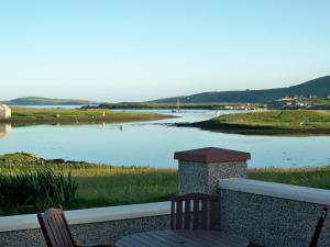 a view of a body of water with two chairs at Tamara Apartment in Sandwick