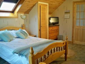 a bedroom with a bed with a television and a dresser at Tamara Apartment in Sandwick