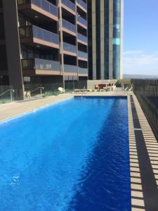 a large swimming pool in front of a building at VUE Penthouse on King William in Adelaide