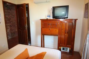 a bedroom with a tv on top of a wooden dresser at Naga Angkor Hostel in Siem Reap