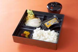 una caja de almuerzo con arroz y otros alimentos en Hotel Carnival (Love Hotel), en Miyaki