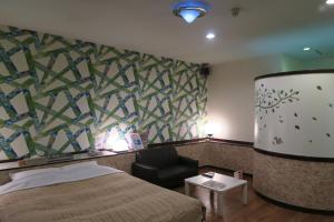 Habitación de hotel con cama y silla en Hotel Carnival (Love Hotel), en Miyaki