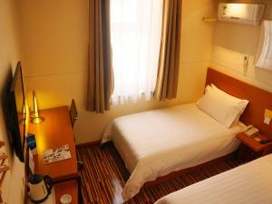 a hotel room with two beds and a window at Goldmet Inn South Loop armed, Datong in Datong