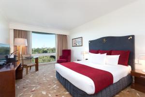 a hotel room with a large bed and a desk and a television at Royal On The Park in Brisbane