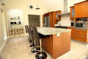 a kitchen with a island with bar stools at Homeplace Retreat Bellaghy Top Rated Property for Families Min 2 nights in Bellaghy