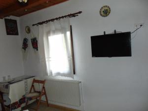 a living room with a flat screen tv on a wall at Casutele Din Moisei in Moisei