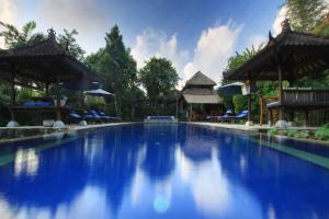 een zwembad in een resort bij Nara Ubud Cottage by Mahaputra in Ubud