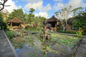 een tuin met een fontein en waterlelies bij Nara Ubud Cottage by Mahaputra in Ubud