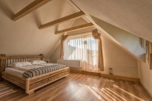 a bedroom with a bed and a large window at Magnolia Resort Chalets in Vişeu de Sus