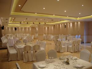 a banquet hall with white tables and white chairs at Selefkos Palace in Igoumenitsa