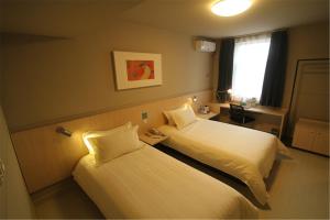 Un pat sau paturi într-o cameră la Jinjiang Inn Changzhi Bayi Square