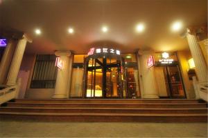 ein Gebäude mit einer Treppe vor einem Laden nachts in der Unterkunft Jinjiang Inn Changzhi Bayi Square in Changzhi