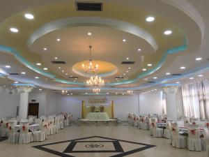 um salão de banquetes com mesas e cadeiras e um lustre em Hotel Albatros em Prizren