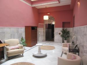 ein Wohnzimmer mit roten Wänden und Stühlen in der Unterkunft Life Apartments Quintana in Sevilla