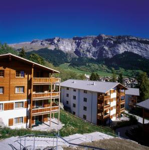 a apartment building with a mountain in the background at Hapimag Ferienwohnungen Flims in Flims