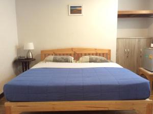 a bedroom with a bed with a blue blanket at Mountain View GuesthouseChiangmai in Chiang Mai