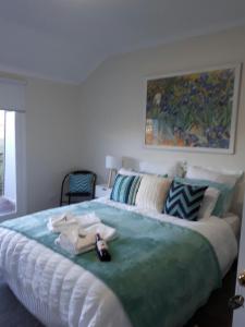 a bedroom with a bed and a painting on the wall at Rosewhite House in Myrtleford