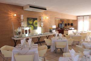 a dining room with white tables and white chairs at Mosate Lodge in Polokwane