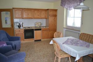 a kitchen with a table and a table and chairs at Haus Cäcilia in Warmensteinach