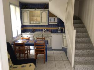 a kitchen with a table and chairs and a staircase at Maison vacances Noirmoutier Barbatre in Barbâtre