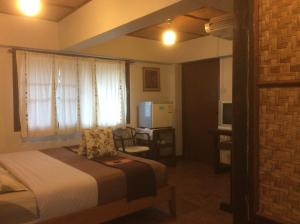 a bedroom with a bed and a window and a desk at Mountain View GuesthouseChiangmai in Chiang Mai