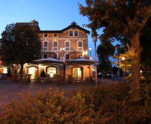 un edificio con tavoli e ombrelloni di fronte ad esso di Hotel La Torre a Torreglia