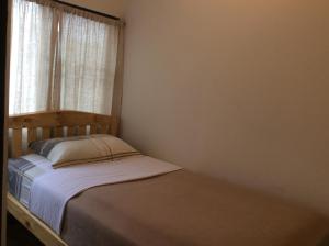 a small bed in a room with a window at Mountain View GuesthouseChiangmai in Chiang Mai