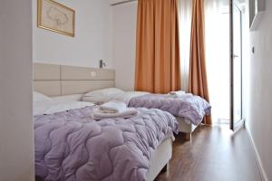 a bedroom with two beds with purple comforter at Hotel No-1 in Međugorje