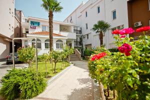a house with palm trees and flowers in front of it at Hotel No-1 in Međugorje