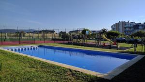 a swimming pool in a park with a playground at A Mariña Adelina in Barreiros