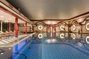 uma piscina num edifício com colunas vermelhas em Maritim Hotel Bad Wildungen em Bad Wildungen