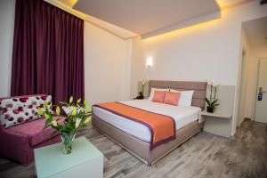 una camera d'albergo con un letto e un divano di Elysium Hotel a Dhërmi